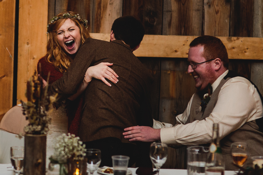 Candid moment of bride and groom at Polmenna Barn wedding reception in Campbellford, Ontario